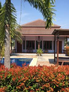eine Villa mit einem Pool und einem Haus in der Unterkunft Waterside Resort in Pran Buri