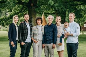 een familie die poseert voor een foto in een park bij Romantik Hotel Jagdhaus Eiden am See in Bad Zwischenahn