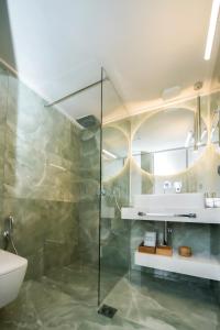 y baño con ducha, aseo y lavamanos. en Luxury Premium Suite #4, en Chalkida