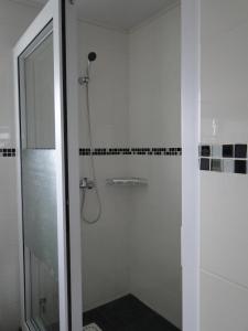 baño con ducha y puerta de cristal en Hotel H1 Antsirabe, en Antsirabe