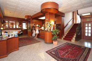 a lobby of a hotel with people standing at a counter at Hotel Riviera in Riva del Garda