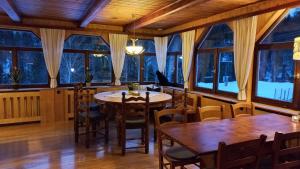 a dining room with tables and chairs and windows at Landhaus Bad Hopfreben in Schoppernau