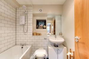 La salle de bains est pourvue d'une baignoire, d'un lavabo et de toilettes. dans l'établissement *Amazing Location!*In heart of the City. 2BR & Cot, à Édimbourg