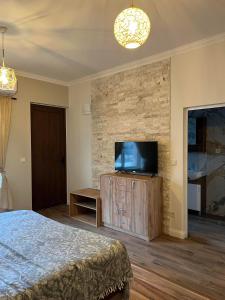 a bedroom with a bed and a flat screen tv at Elegant and cozy room ARAKS in Kostinbrod