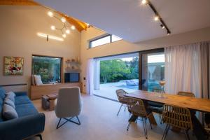 uma sala de jantar e sala de estar com mesa e cadeiras em Olive green villas em Lefkada