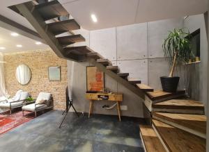 a living room with a wooden staircase and a desk at Lavender Beach House in Durrës