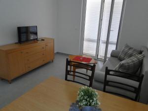 a living room with a couch and a table at Apartmani Tepli Bok in Primošten