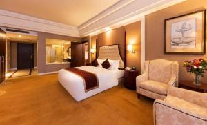 a hotel room with a bed and a chair at NH Shenyang Yuhong in Shenyang