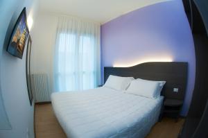 sypialnia z dużym białym łóżkiem i oknem w obiekcie 29 Cav Apartments w mieście Bollate