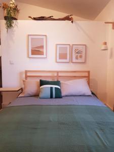 una camera da letto con un letto con cuscini sopra di Quintinha do Sal - Casa das Flores ad Alcácer do Sal