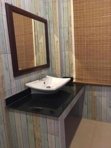 a bathroom with a sink and a mirror on a counter at Waterside Resort in Pran Buri