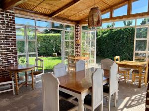 a dining room with a wooden table and chairs at La Locanda in Ruhengeri