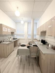 a large kitchen with a table and chairs in it at Keja Aparts - 02 Gdynia Centrum in Gdynia