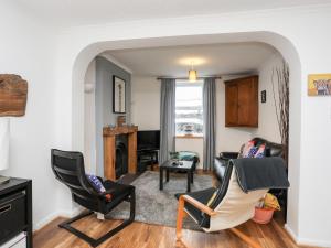 a living room with two chairs and a fireplace at 5 Thomas Street in Llanberis
