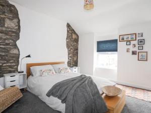 een slaapkamer met een groot wit bed en een raam bij 5 Thomas Street in Llanberis