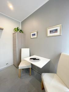 a room with a white table and two chairs at Keja Aparts - 02 Gdynia Centrum in Gdynia