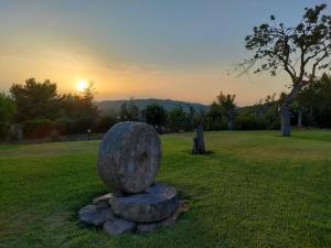 a stone statue in a field with the sunset in the background at Agroturismo Can Marquet - Adults Only in Santa Gertrudis de Fruitera