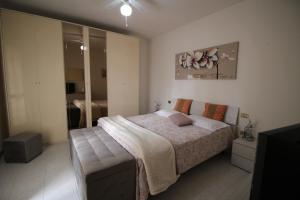 Casa Vacanze Doralice في Barzana: غرفة نوم بسرير كبير وتلفزيون