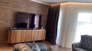 a living room with a couch and a flat screen tv at Lux Apart Karlovo in Karlovo