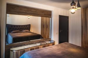 a bedroom with a large mirror above a bed at Lux Apart Karlovo in Karlovo