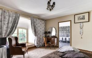 - une chambre avec un lit, un bureau et un miroir dans l'établissement Château d'Ermenonville, à Ermenonville