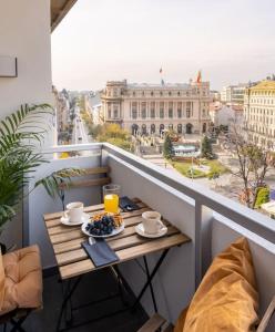 a table on a balcony with a view of a city at Sunny 2BR Flat - Top Location - Stunning Views in Bucharest