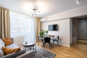 a living room with a couch and a table at Sunny 2BR Flat - Top Location - Stunning Views in Bucharest
