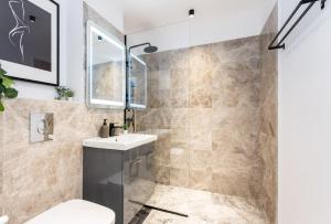 a bathroom with a sink and a toilet and a shower at Sunny 2BR Flat - Top Location - Stunning Views in Bucharest +37 photos