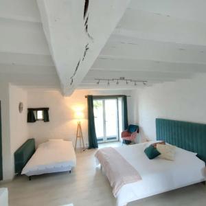 a bedroom with two beds and a window at Chambre d'hôtes des Gâtines in Berthegon