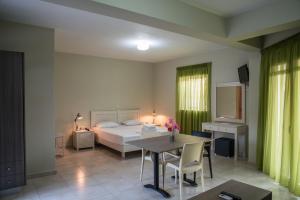 1 dormitorio con 1 cama, mesa y sillas en Fournia Village en Kyllíni