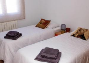 two beds with towels on them in a room at El Pisuco de Lu entre Puertochico y El Sardinero in Santander