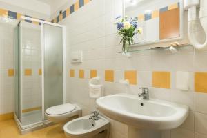 uma casa de banho com um lavatório, um WC e um chuveiro em Bosco Canoro Bibione Resort em Bibione
