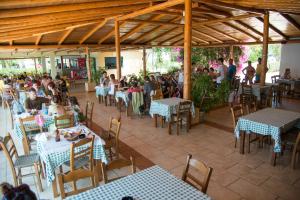 un grupo de personas sentadas en mesas en un restaurante en Fournia Village, en Kyllini
