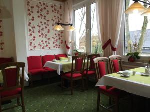 a restaurant with red chairs and tables and a window at Thermen Hotel Pension Villa Holstein in Bad Salzuflen