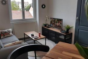 uma sala de estar com um sofá e uma mesa em Appartement cosy proche la Part Dieu em Lyon