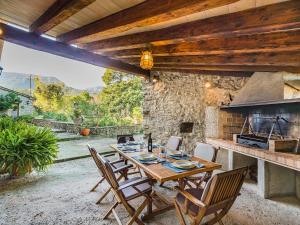 Villa Can Fanals by SunVillas Mallorca في بوينسا: طاولة وكراسي خشبية في فناء مع موقد