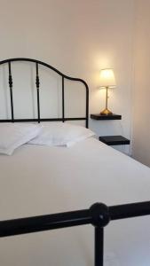 uma cama branca com uma moldura preta e um candeeiro em Appartement cosy proche la Part Dieu em Lyon
