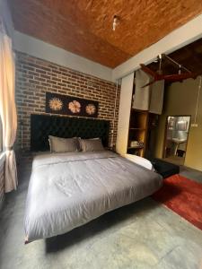 a bedroom with a large bed and a brick wall at Eagleye Langkawi in Tanjung Rhu