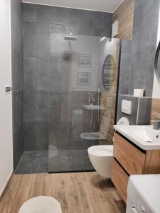 Sopot Holiday - Apartament przy plaży في سوبوت: حمام مع دش ومرحاض ومغسلة