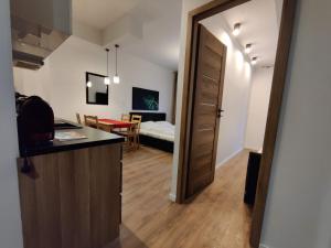 Sopot Holiday - Apartament przy plaży في سوبوت: غرفة مع مطبخ وغرفة مع غرفة نوم