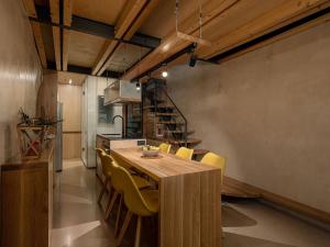 uma sala de jantar com uma mesa de madeira e cadeiras amarelas em Casa Sorvolou em Chania Town