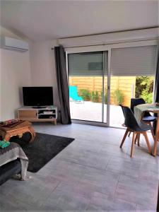 salon z dużymi przesuwnymi szklanymi drzwiami prowadzącymi na patio w obiekcie L'ANNEXE endroit zen et chaleureux. Jacuzzi extérieur w mieście Brignoles