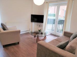 sala de estar con sofá y mesa de cristal en Modern Spacious Apartments en Bishops Stortford