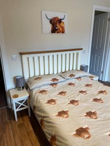 a bed in a bedroom with a cow on the wall at Carnach in Fort William