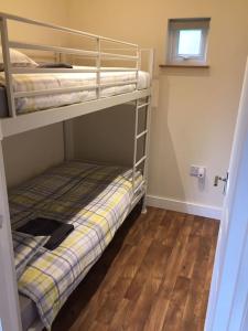 a small room with two bunk beds and a window at Carnach in Fort William