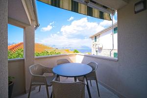 un tavolo e sedie su un balcone con vista di Apartment Postira a Postira (Postire)