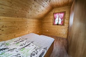 1 dormitorio con 1 cama en una habitación de madera en Princess's vineyard cottage, en Mirna Peč