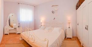 a white bedroom with a white bed and a mirror at Villa Lorena in Sutivan +14 photos