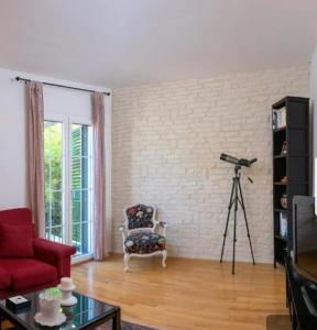 een woonkamer met een rode stoel en een camera bij Villa Lorena in Sutivan