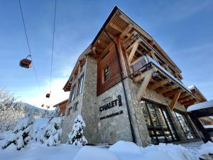 budynek w śniegu z wyciągiem narciarskim w obiekcie Chalet One Jasná w Demianowskiej Dolinie